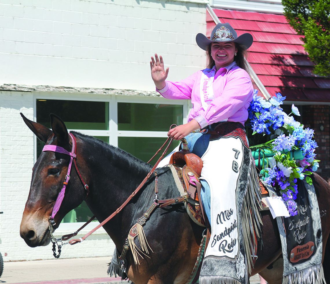 Visiting rodeo royalty wave to the crowd